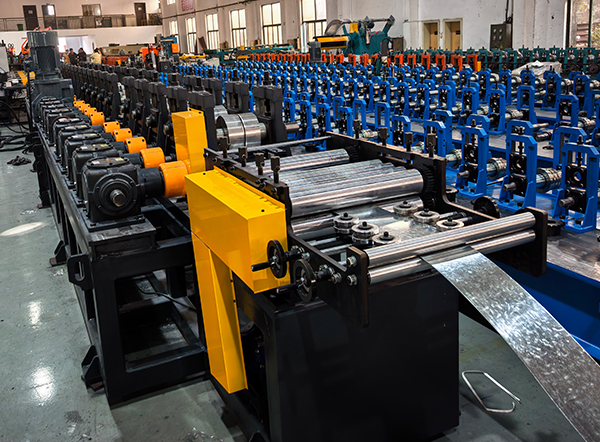 Precision Guiding, Leveling, and Feeding unit entering a heavy-duty roll forming line with gearbox transmission